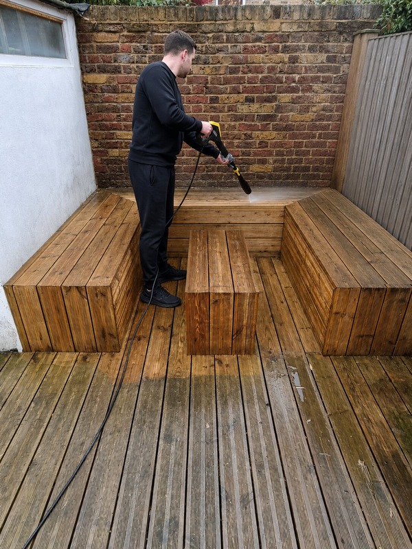 man-using-a-pressure-washer-to-clean-decking
